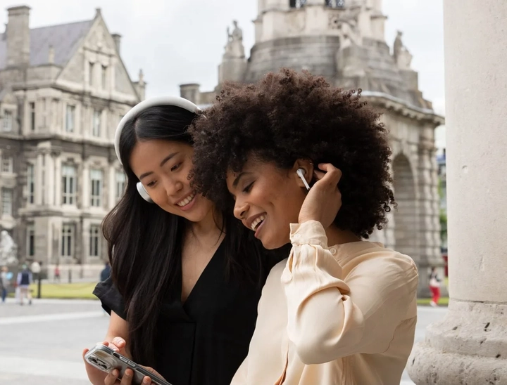 two women looking at a phone and smiling