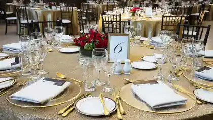 table with flowers, glasses, and gold cutlery