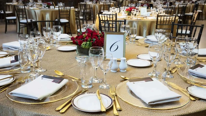 table with flowers, glasses, and gold cutlery