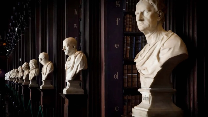 row of white busts in a dark library