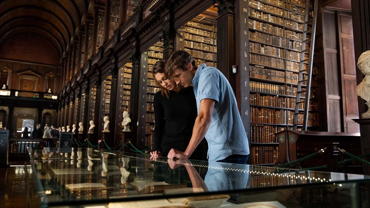 a couple looking down at a display case in an old library
