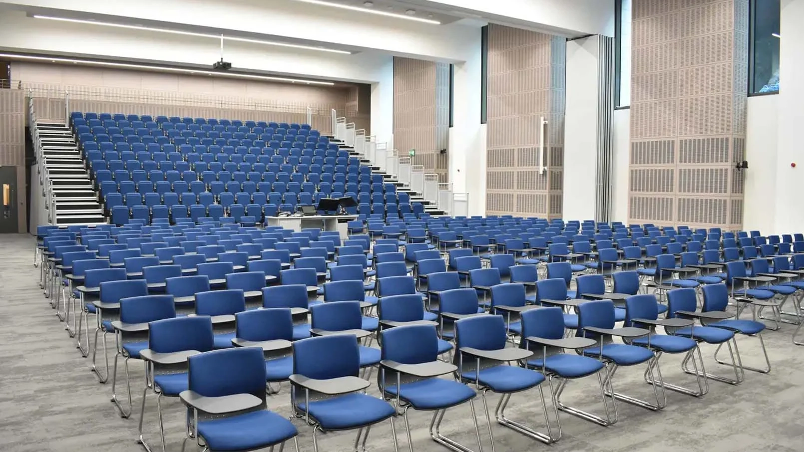 rows of blue chairs in a lecture theatre with raised seating