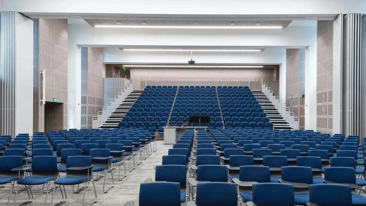 rows of blue seats in a lecture hall