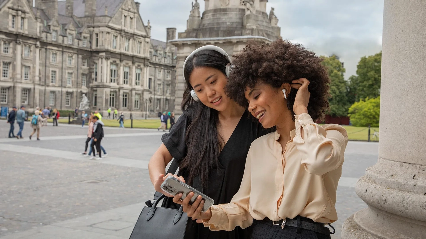 two women looking at a phone on a self guided tour of trinity
