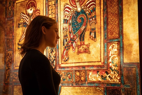 woman looking at a large section of the book of kells on a display