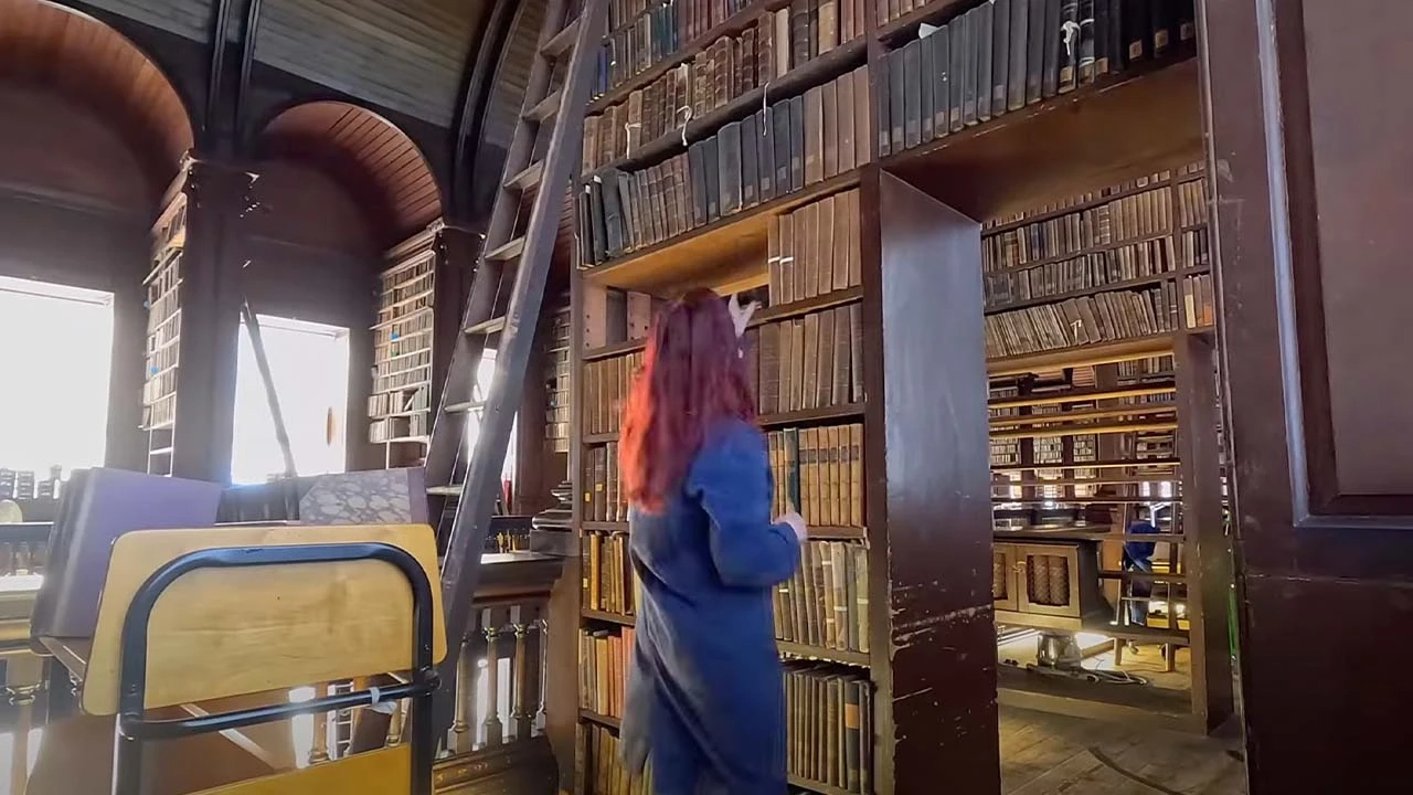 woman pointing at shelves of old books