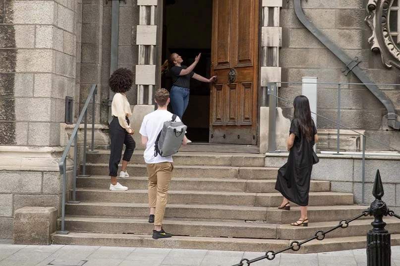 tour guide pointing at a large door