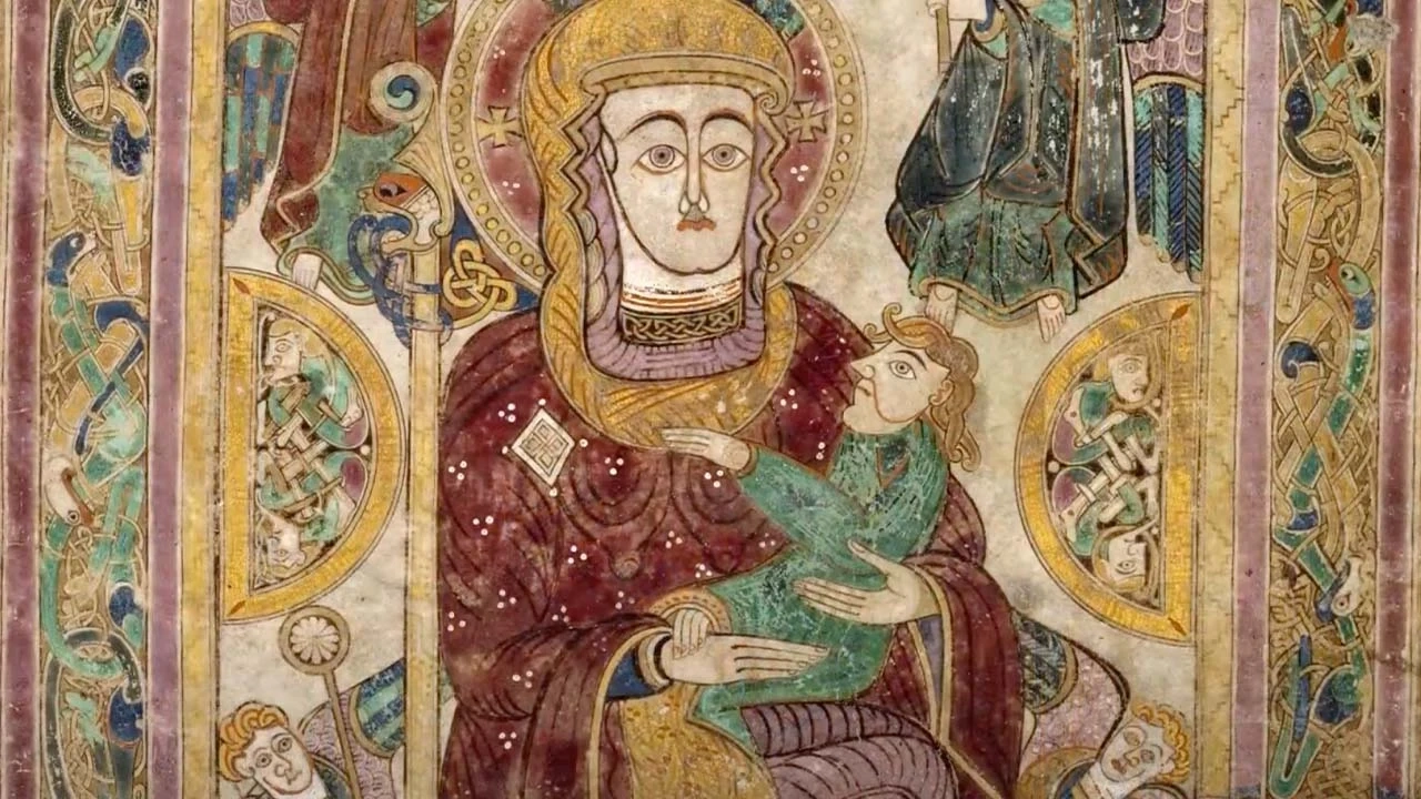 close up of section of the book of kells with woman holding a baby