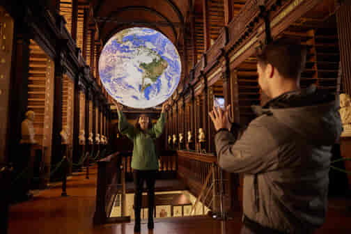 A couple taking a photo of Gaia in the Old Library
